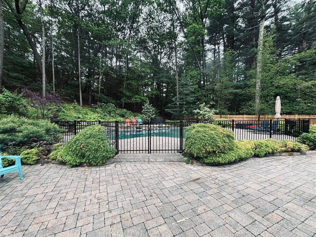 Black aluminum pool fence with paver patio