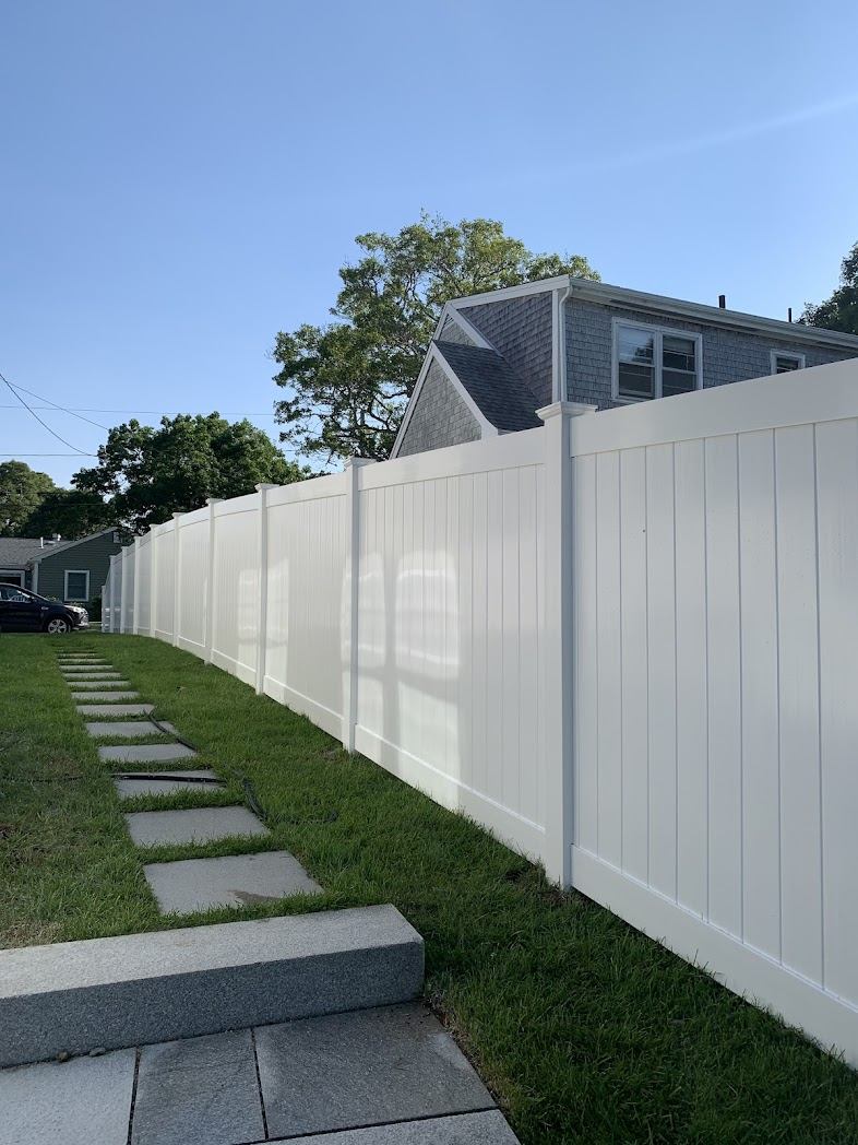 White vinyl privacy fence along a stone path