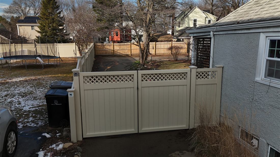 Tan vinyl privacy fence with lattice top