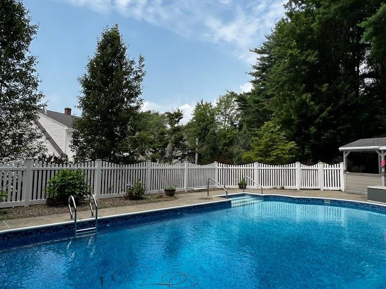 White vinyl picket fence around a pool